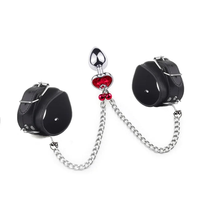 GHALLAS bondage stimulation set with black leather cuffs, silver chains, and metal plug with red heart detail