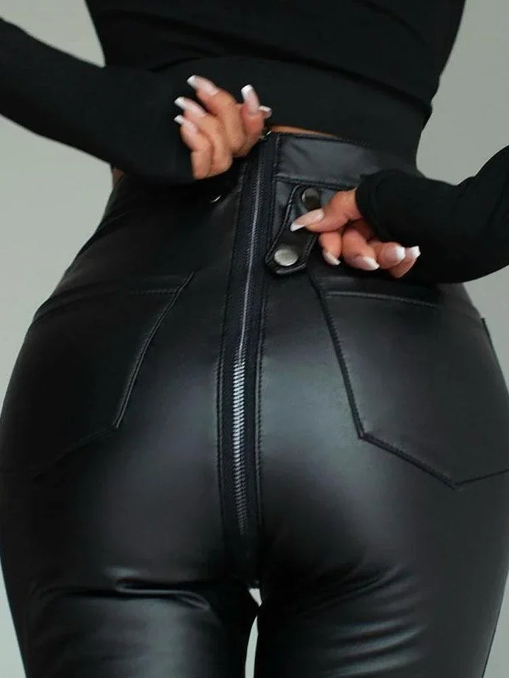 Close-up of black leather zipper trousers showing the back zipper and pocket details